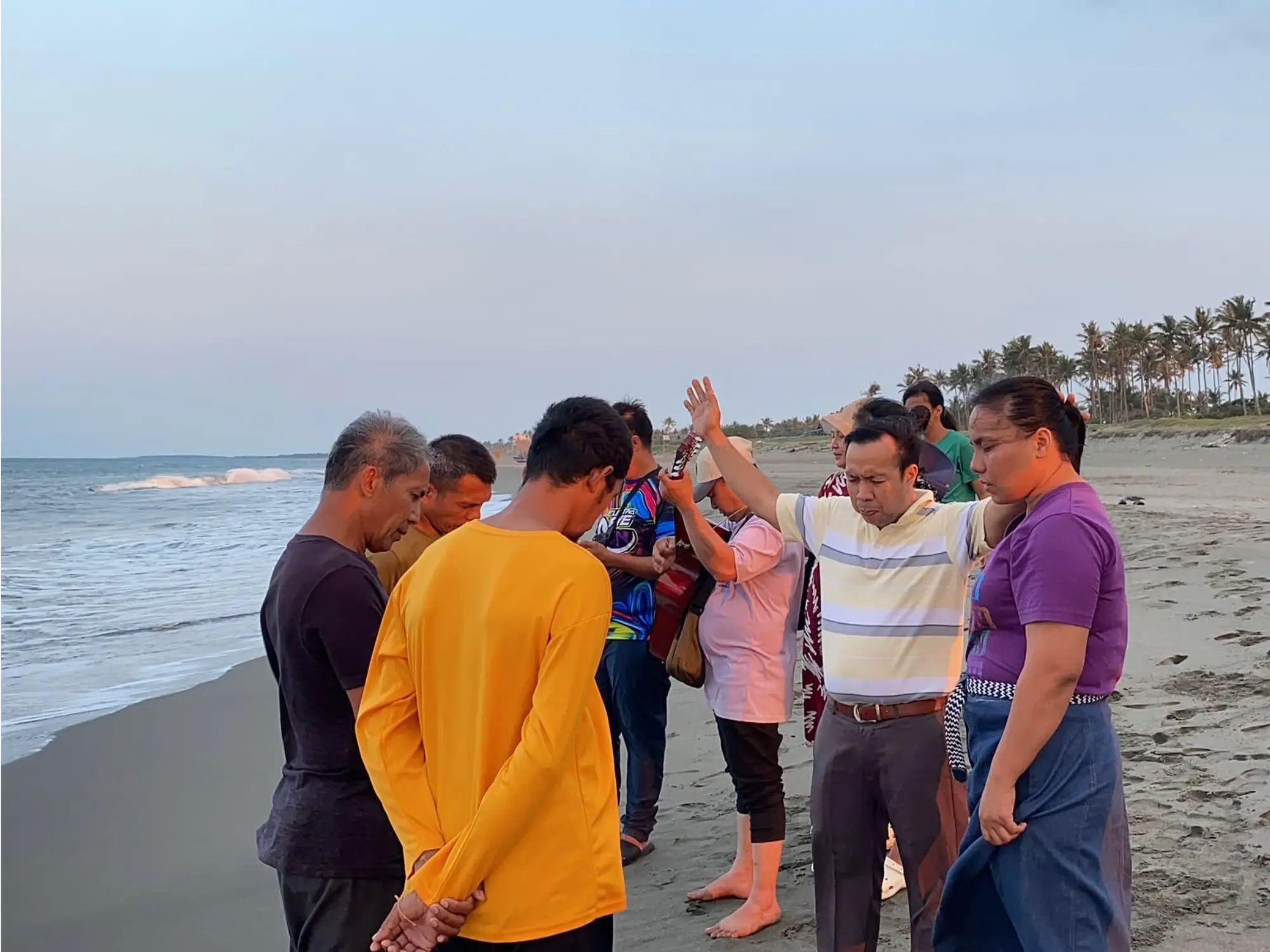 Church members praying together after the baptisms